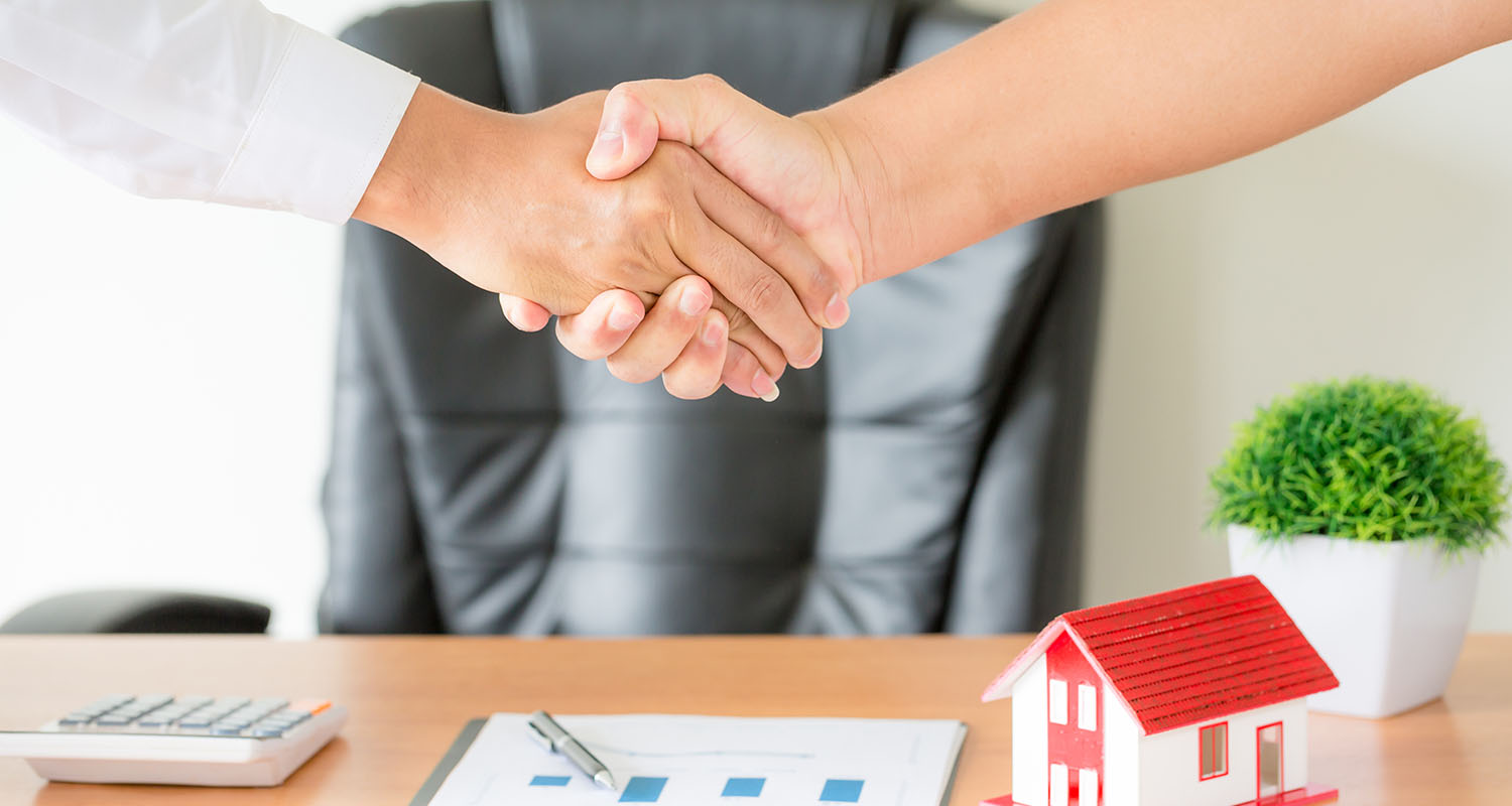 hands of agent and client shaking hands after signed contract bu